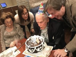 Dave Roberts blows out candles on birthday cake surrounded by his wife Dorothy, daughter Jody and son Jimmy. (Photo courtesy of Temple Emanuel)