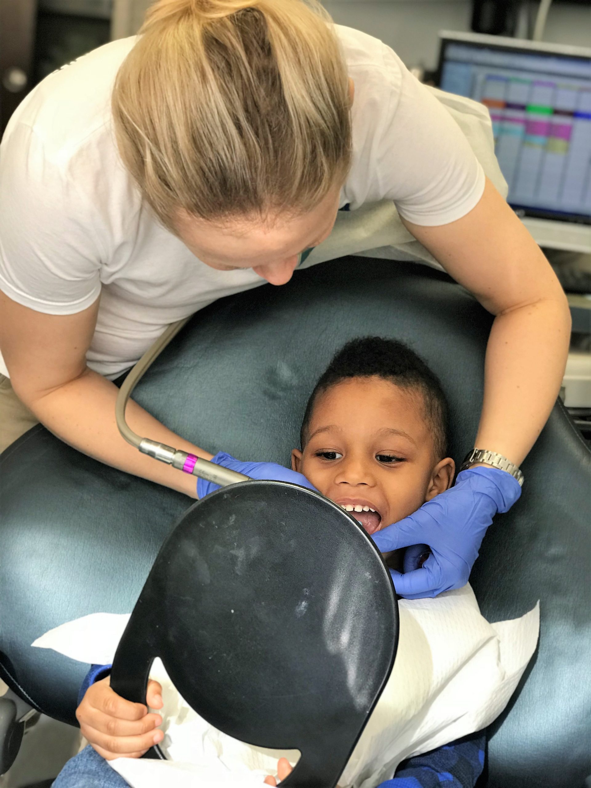 Anna Kwasnik, a dentist with Passes Dental Care in Great Neck, works on cleaning a child's mouth. (Photo courtesy of Passes Dental Care)