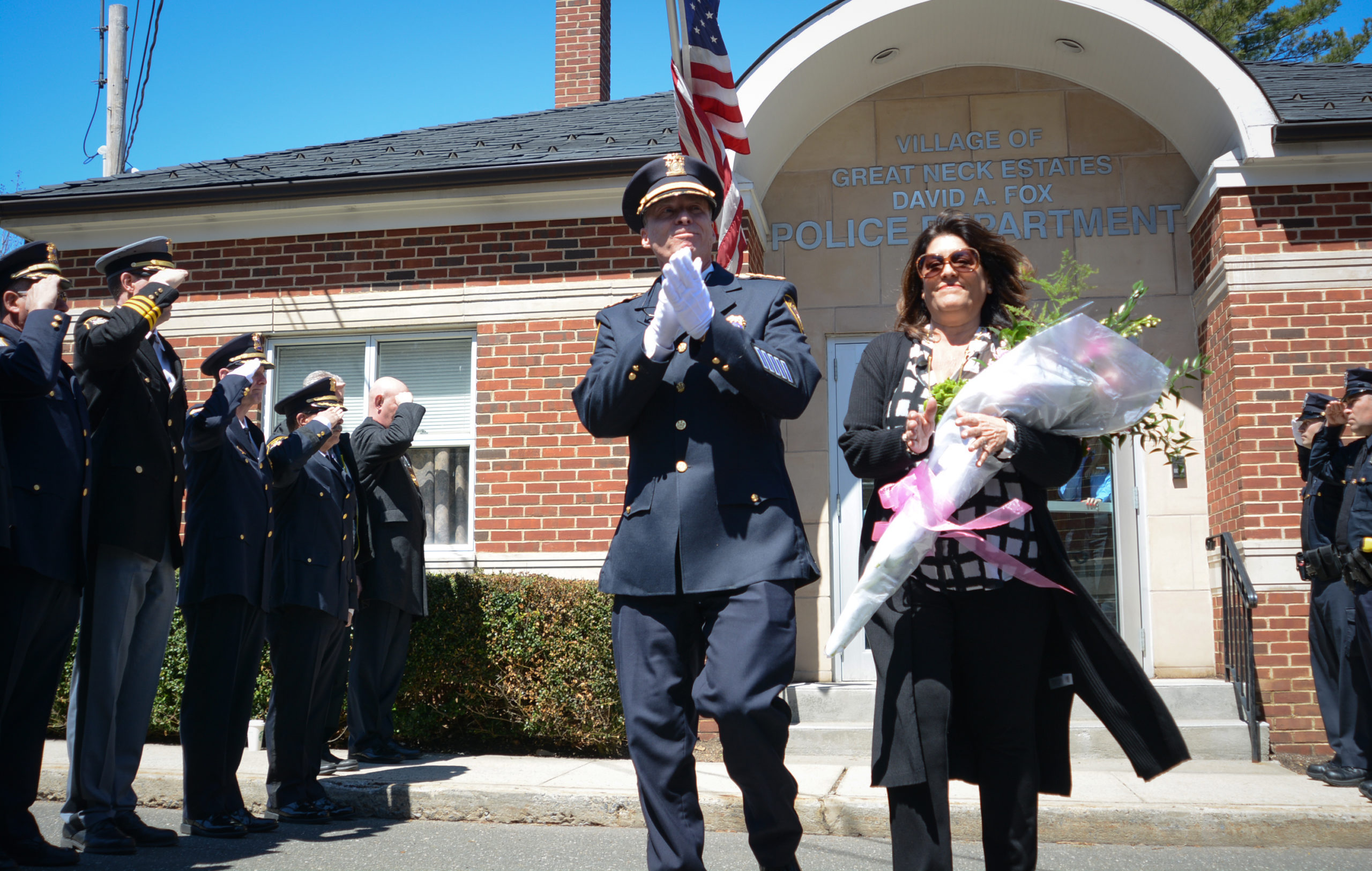 Outgoing Great Neck Estates Police Chief John Garbedian steps out from the David A. Fox police department building on Cedar Drive, greeted by family and officers from all around Nassau County. Ricardo Moreno is succeeding him as police chief. (Photo by Janelle Clausen)