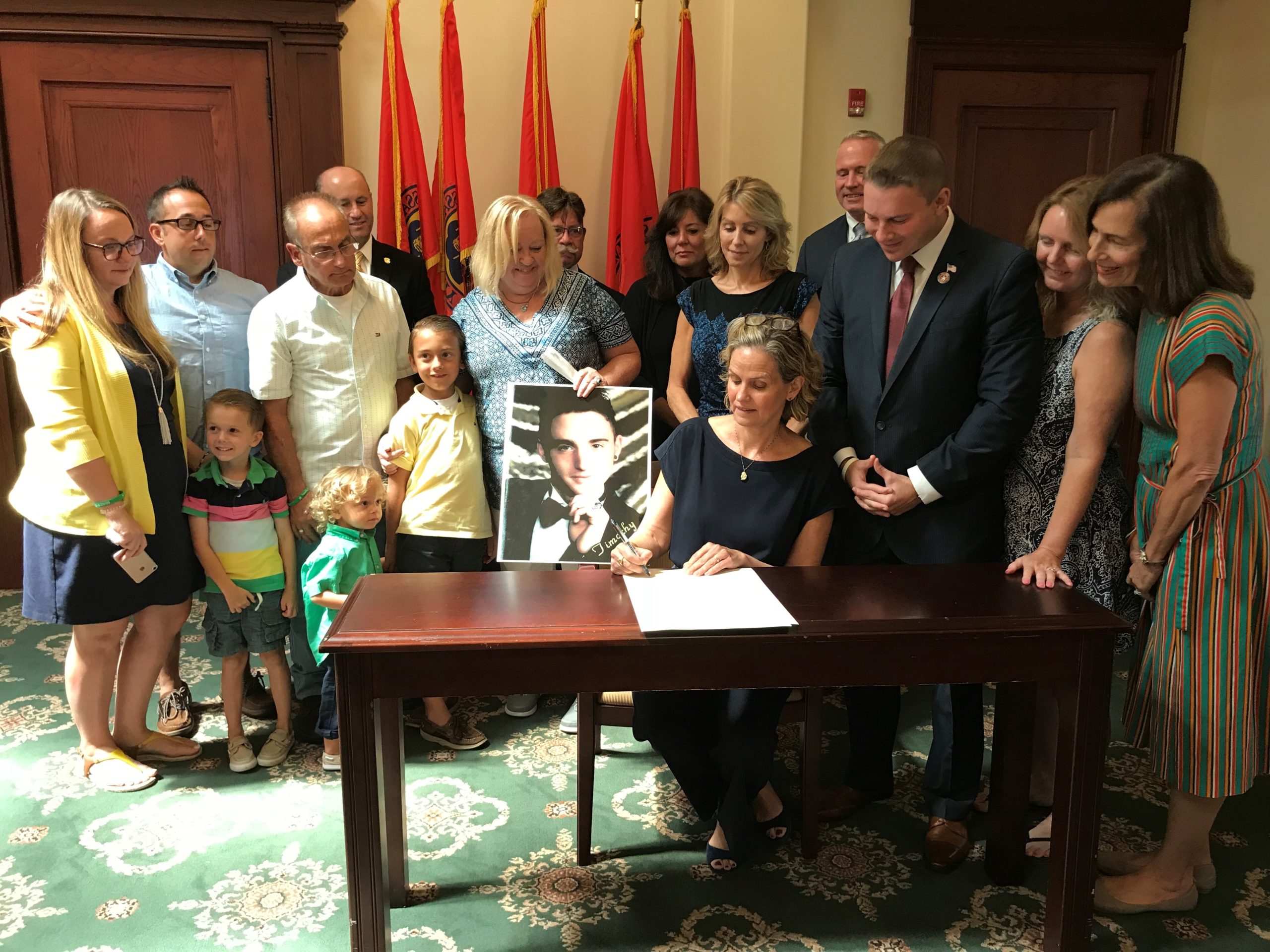 Nassau County Executive Laura Curran signs a pair of substance abuse bills into law as Legislator Joshua Lafazan and others look on. (Photo courtesy of Nassau County Executive Laura Curran's office)