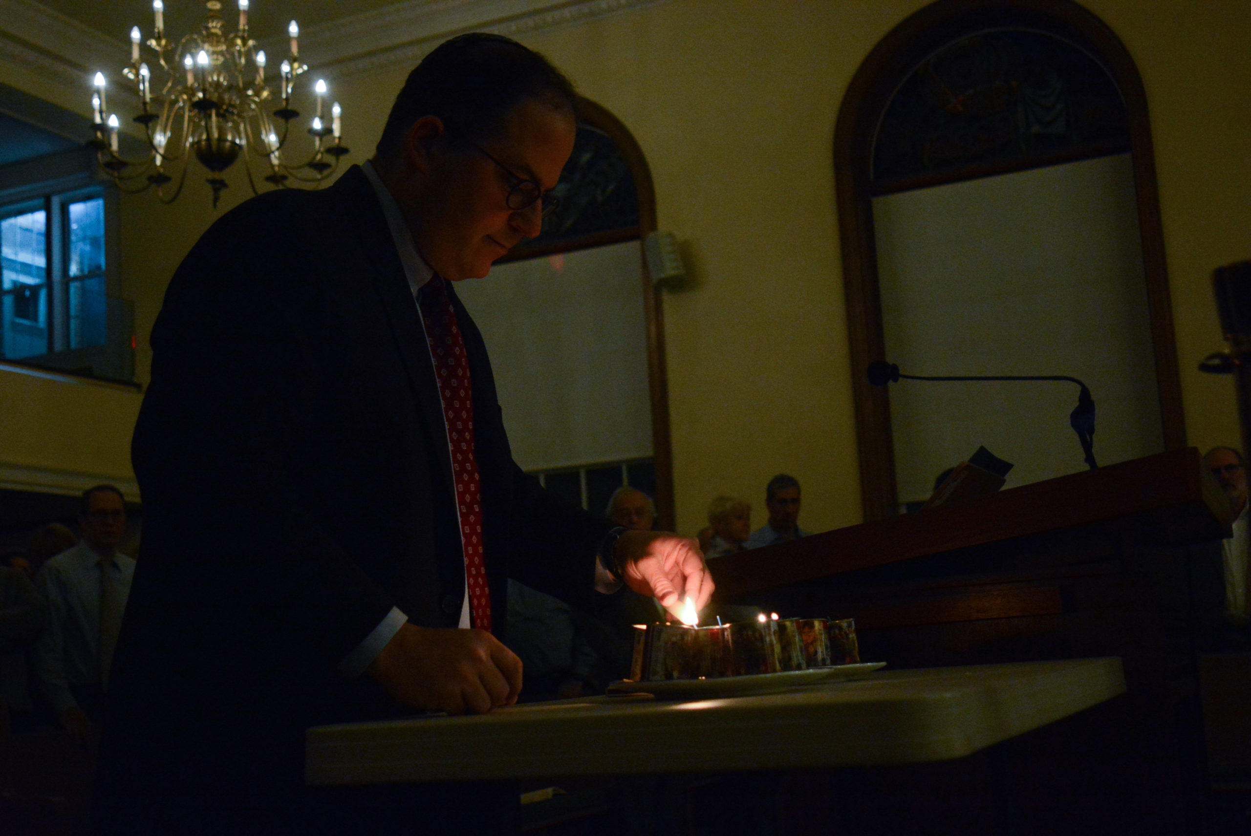 Rabbi Daniel Schweber of Temple Israel lights candles to honor the 11 people killed in the Tree of Life Congregation shooting. (Photo by Janelle Clausen)