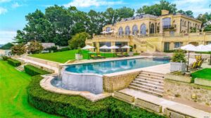Among the mansion's features, seen here, are a limestone exterior, blue marble pool, and a stone deck. (Photo courtesy of Daniel Gale Sotheby's International Realty)