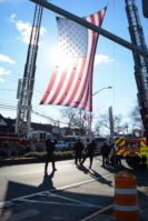 Alert Fire Company hoisted a massive American flag to commemorate Ray Plakstis. (Photo by Janelle Clausen)