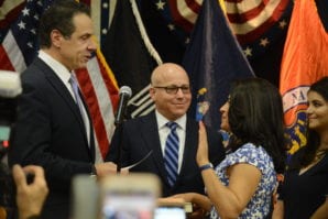 New York Gov. Andrew Cuomo swears in Anna Kaplan as state Senator as her husband Darren, a trustee in the Village of Kensington, looks on. (Photo by Janelle Clausen)