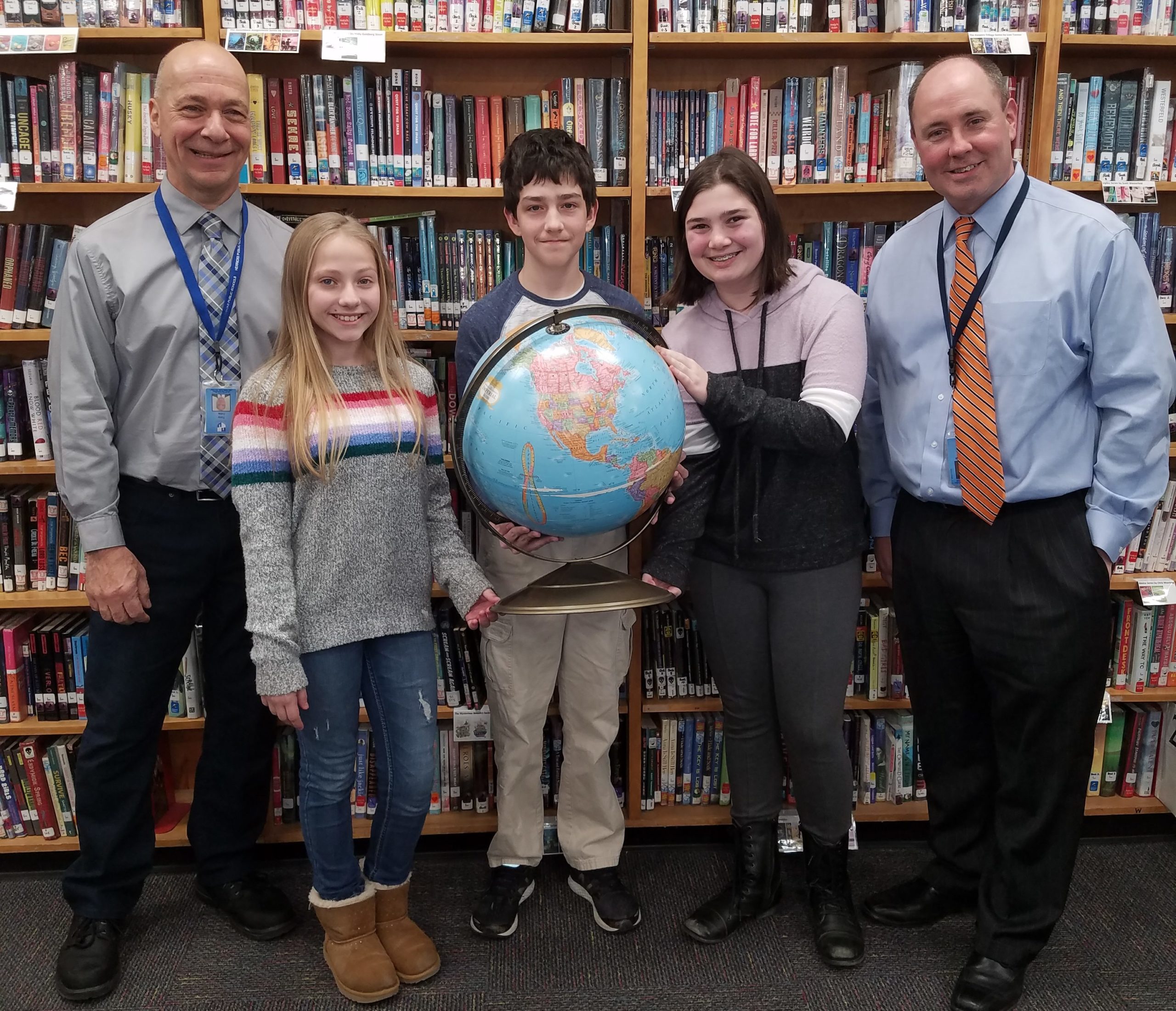 Michael Zanetti, center, is pictured with runners-up Sasha Stern and Isabella Pavolvici, along with Herricks Middle School Principal Brian McConaghy and Social Studies Chairperson Tony Cillis. (Photo courtesy of Herricks Public Schools)